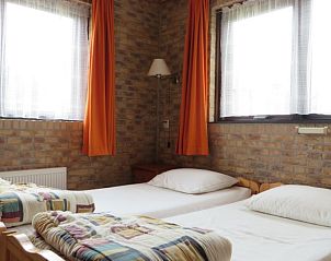 Tweepersoons slaapkamer in Duinrust, Schiermonnikoog, met warme en uitnodigende inrichting.