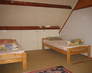Zolderkamer met twee bedden in Duinrust vakantiehuis op Schiermonnikoog, ideaal voor kinderen.
