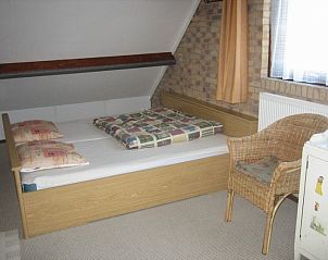 Ruime slaapkamer met tweepersoonsbed in Duinrust, Schiermonnikoog, met rustieke charme.