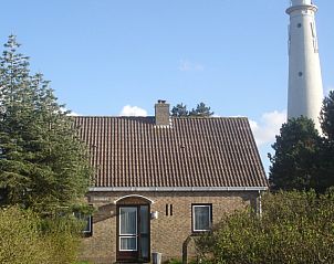 Voorzijde van vakantiehuis Duinrust op Schiermonnikoog met vuurtoren op de achtergrond.