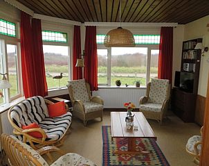 Gezellige woonkamer van Zeerust vakantiehuis op Schiermonnikoog met comfortabele stoelen en uitzicht op de natuur.