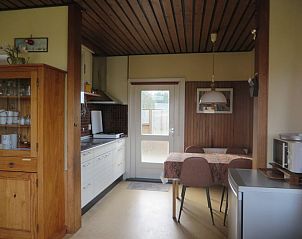 Moderne keuken van Zeerust vakantiehuis in Schiermonnikoog met eethoek en toegang tot het terras.