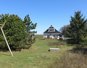 Groene tuin rondom Zeerust vakantiehuis op Schiermonnikoog met weids uitzicht en speelruimte.