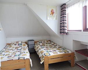 Knusse slaapkamer van Zeerust vakantiehuis op Schiermonnikoog met twee bedden en veel natuurlijk licht.
