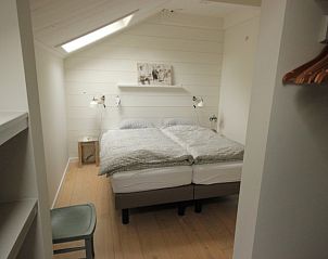 Sfeervolle slaapkamer in Opa's huis, vakantiehuis Schiermonnikoog, met comfortabel tweepersoonsbed.
