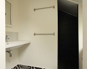 Stijlvolle badkamer in Opa's huis, vakantiehuis Schiermonnikoog, met uniek tegelpatroon op de vloer.