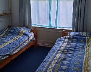 Knusse slaapkamer met twee bedden in Stachouwer vakantiehuis, Schiermonnikoog, voor een ontspannen nachtrust.