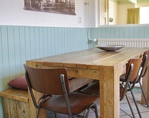 Eetruimte in Klaver Vier vakantiehuis met houten tafel, Schiermonnikoog.
