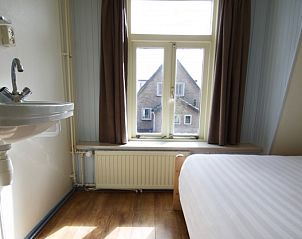Lichte slaapkamer in Klaver Vier vakantiehuis met uitzicht op Schiermonnikoog.