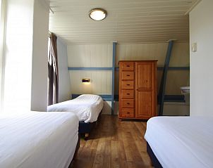 Ruime slaapkamer met drie bedden in Klaver Vier, Schiermonnikoog.