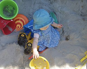 Peuter speelt in zandbak bij Klaver Vier vakantiehuis, Schiermonnikoog.
