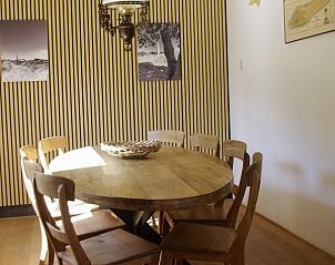 Eetkamer in Twa Blomkes vakantiehuis op Schiermonnikoog met houten tafel en sfeervolle verlichting.