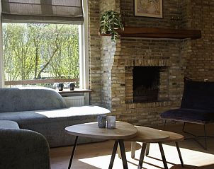 Zithoek in Twa Blomkes vakantiehuis op Schiermonnikoog met uitzicht op de groene tuin.