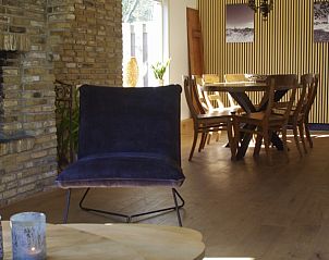 Open woonkamer en eetkamer in Twa Blomkes vakantiehuis op Schiermonnikoog, met veel natuurlijk licht.
