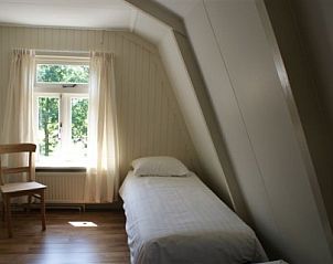 Knusse eenpersoonskamer in Twa Blomkes vakantiehuis op Schiermonnikoog met uitzicht op de tuin.