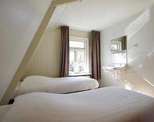 Tweepersoonskamer in Twa Blomkes vakantiehuis op Schiermonnikoog met veel natuurlijk licht en wastafel.