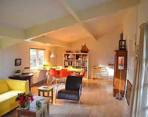 Ruime woonkamer van Hannekommen vakantiehuis met veel lichtinval op Schiermonnikoog, Waddeneilanden.