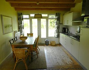 Gezellige keuken in Buutvrij vakantiehuis op Schiermonnikoog met houten eettafel.