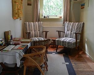Kleine leeshoek in Buutvrij vakantiehuis op Schiermonnikoog met comfortabele stoelen.