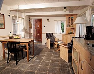 Gezellige binnenruimte van vakantiehuis Poppe in Schiermonnikoog, met houten interieur.