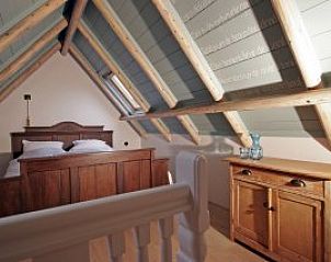 Slaapkamer met houten balken in vakantiehuis Poppe, Schiermonnikoog, Waddeneilanden.