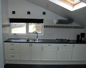 Moderne keuken in vakantiehuis Henny, Schiermonnikoog, met stijlvolle inbouwapparatuur en veel natuurlijk licht op de Waddeneilanden.