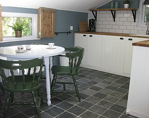 Knusse keuken in vakantiehuis Adje op Schiermonnikoog met eettafel en groen uitzicht.