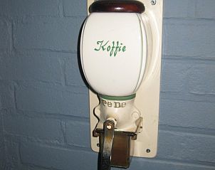 Authentieke koffiemolen in vakantiehuis Adje op Schiermonnikoog voor een nostalgische sfeer.