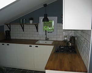 Moderne keuken in vakantiehuis Adje op Schiermonnikoog met houten aanrecht en ruime opbergruimte.