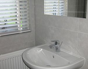 Stijlvolle badkamer in vakantiehuis Adje op Schiermonnikoog met wastafel en modern design.