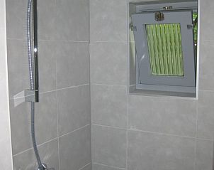 Douche in vakantiehuis Adje op Schiermonnikoog met frisse uitstraling en klein raam.