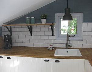 Keukenblad in vakantiehuis Adje op Schiermonnikoog met witte tegels en open plank.