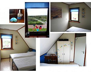 Tweede slaapkamer van Casa Maris op Schiermonnikoog, met uitzicht op de natuur en kleurrijke decoraties.