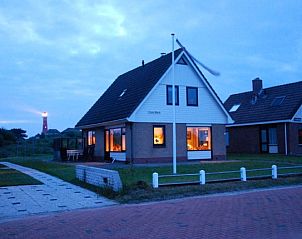 Casa Maris vakantiehuis op Schiermonnikoog bij schemering met warme verlichting.