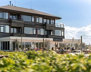 Terrasse des Ferienhauses in Schiermonnikoog, ein Ferienhaus in Schiermonnikoog mit Gsten, die die Sonne genieen.