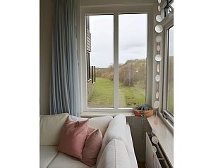 Blick aus dem Inneren des Ferienhauses in Schiermonnikoog, ein Ferienhaus auf den Watteninseln mit grner Umgebung.