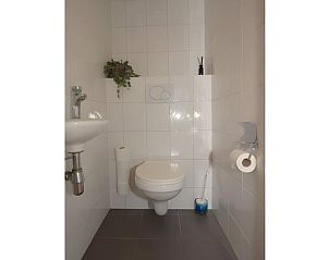 Stilvolle Toilette im Ferienhaus in Schiermonnikoog, ein Ferienhaus auf den Watteninseln mit weien Fliesen.