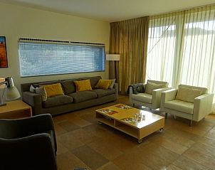 Comfortabele woonkamer met grote ramen in vakantiehuis Hestia op Schiermonnikoog.