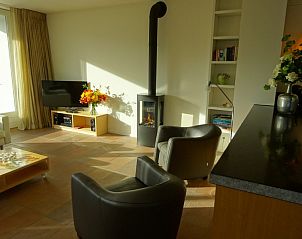 Lichte woonkamer met open haard in vakantiehuis Hestia, Schiermonnikoog.