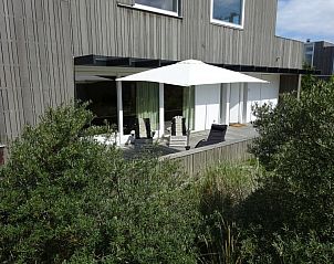 Zonnig terras met parasol bij vakantiehuis Hestia, Schiermonnikoog.