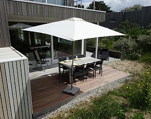 Terras met eettafel en parasol in vakantiehuis Hestia, Schiermonnikoog.