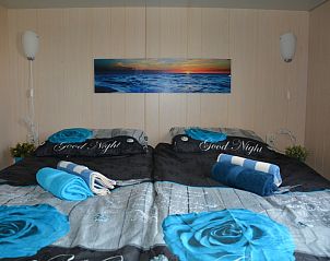 Schlafzimmer in CORIMAR Ferienhaus, Ballum, Ameland mit Doppelbett und Dekoration.